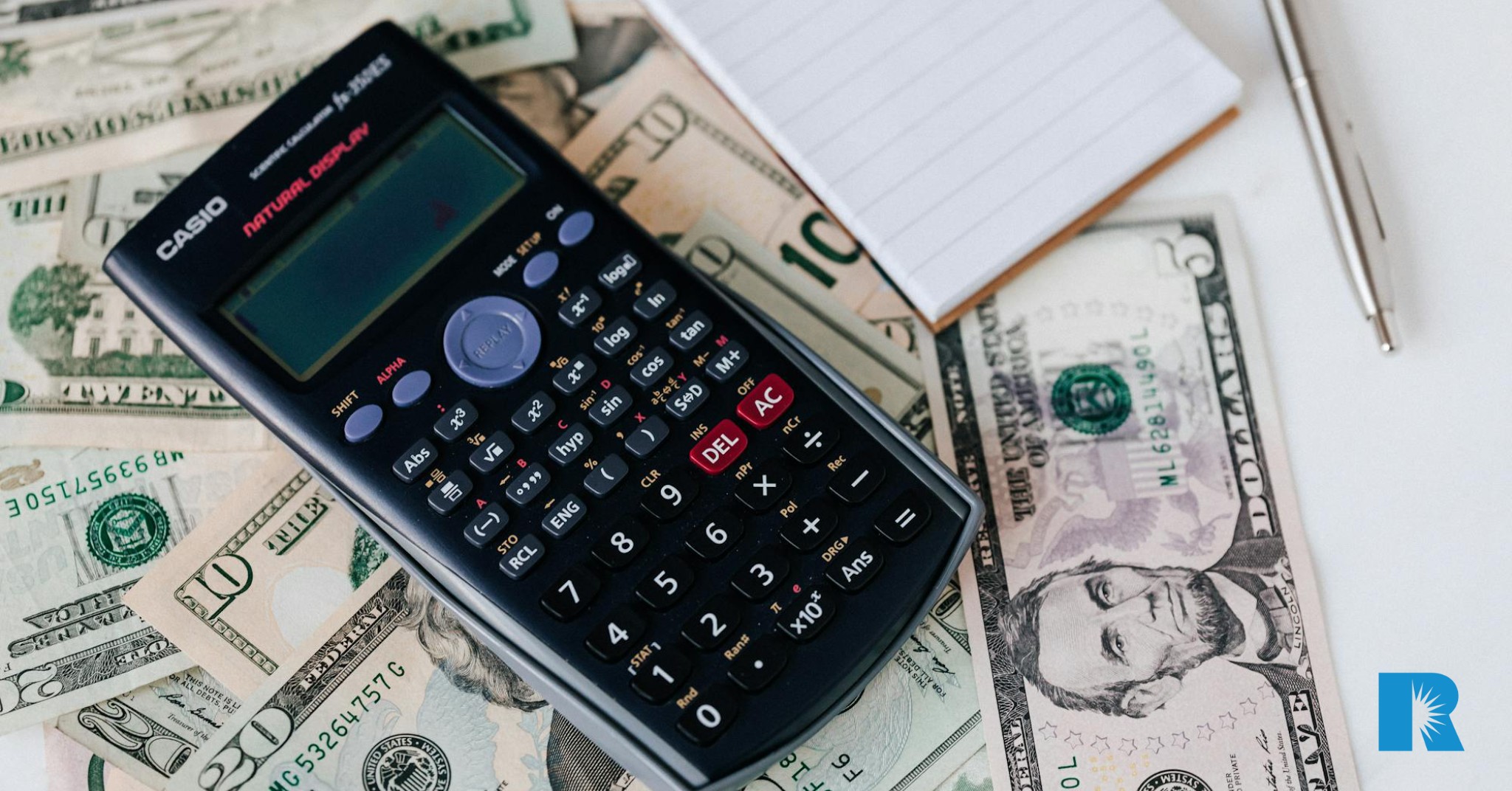 Photo illustration showing a calculator and cash on an agent's desk.